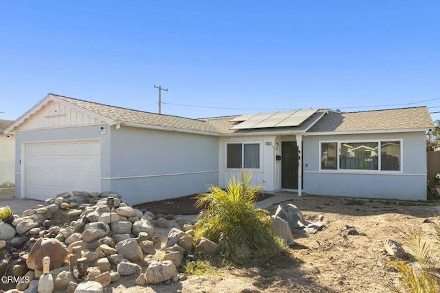 view of front of home featuring solar panels and a garage