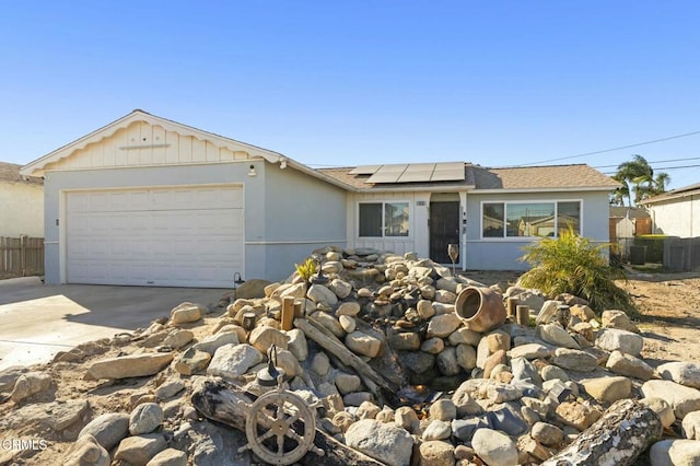 ranch-style home with solar panels and a garage