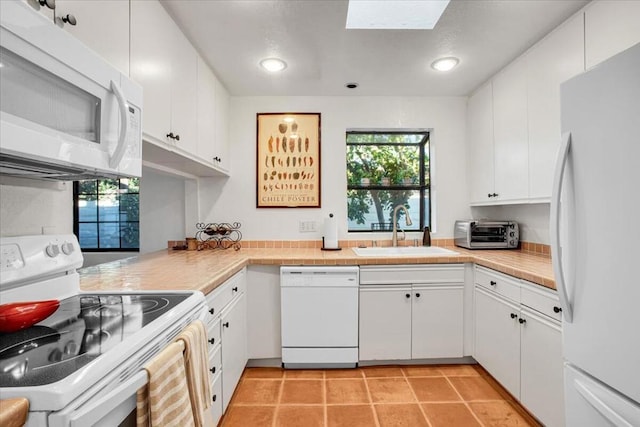 kitchen featuring white cabinetry, sink, and white appliances