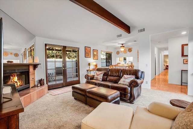 living room with ceiling fan, a fireplace, lofted ceiling with beams, light carpet, and french doors