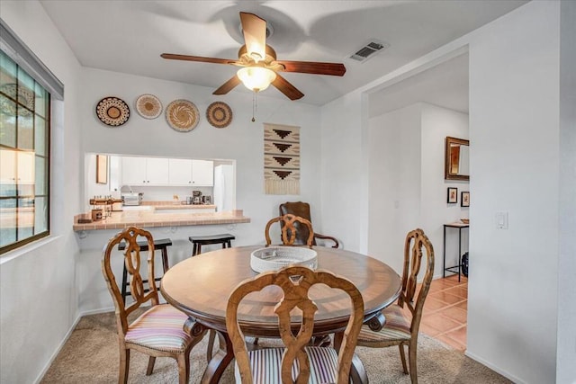 tiled dining area with ceiling fan and a healthy amount of sunlight