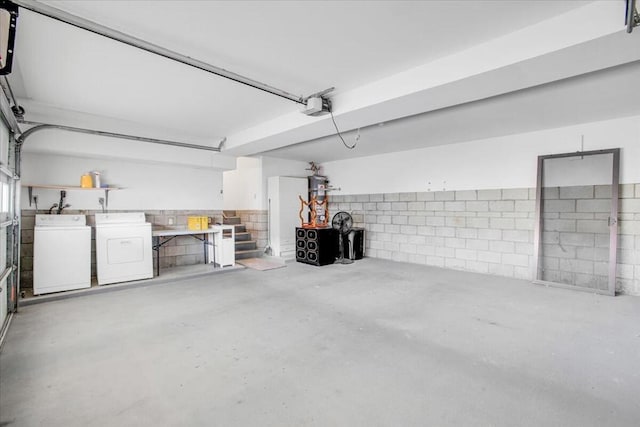 garage with washing machine and dryer and a garage door opener