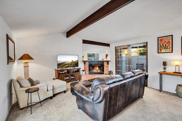 carpeted living room featuring french doors, vaulted ceiling with beams, and a tile fireplace