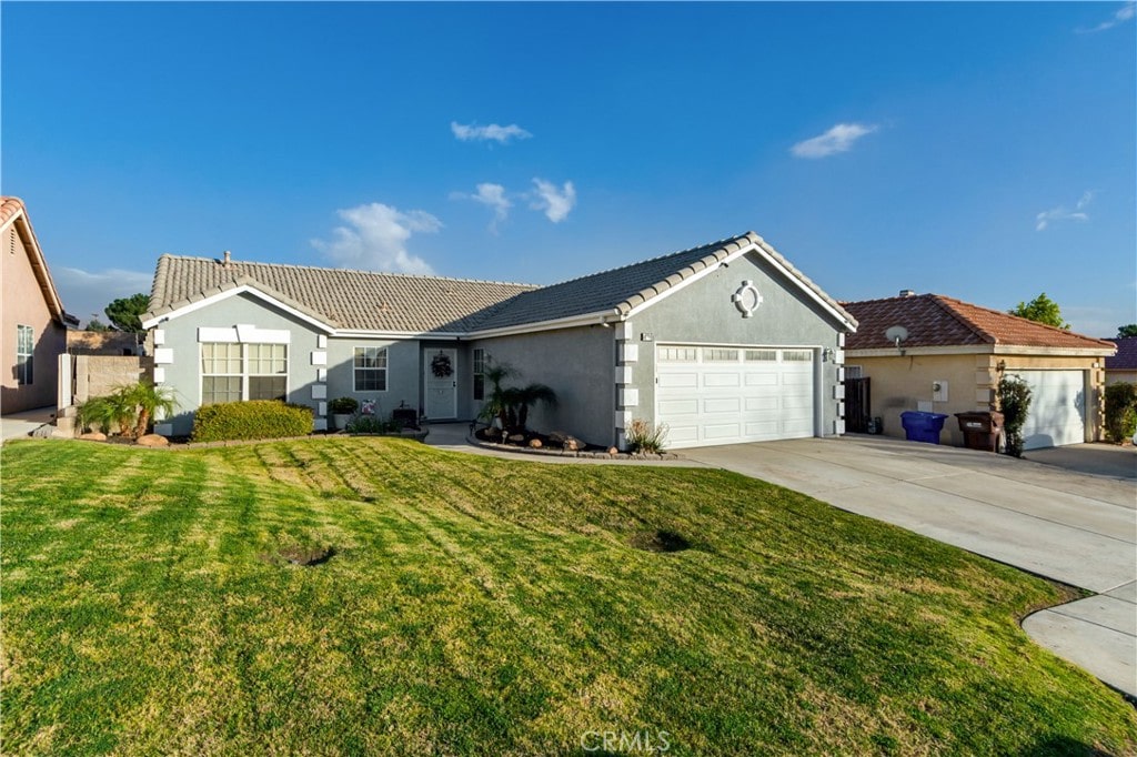 single story home featuring a garage and a front yard