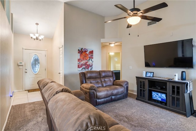 carpeted living room featuring high vaulted ceiling and ceiling fan with notable chandelier