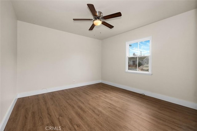 unfurnished room with ceiling fan and dark wood-type flooring