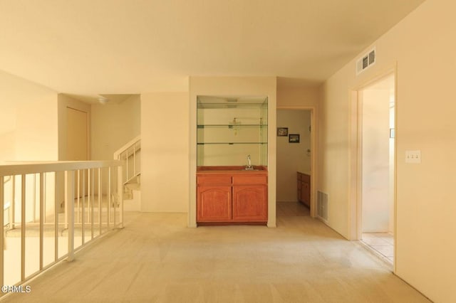 hall with sink and light carpet