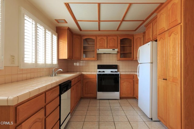 kitchen with tile countertops, decorative backsplash, sink, white appliances, and light tile patterned floors