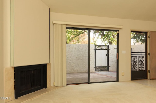 entryway featuring light carpet and a fireplace