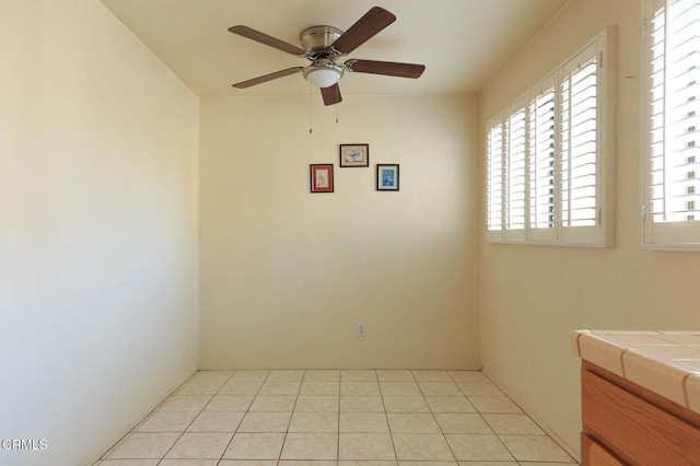 spare room featuring ceiling fan and light tile patterned floors