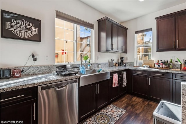 kitchen featuring dark wood-type flooring, dishwasher, light stone counters, and dark brown cabinets