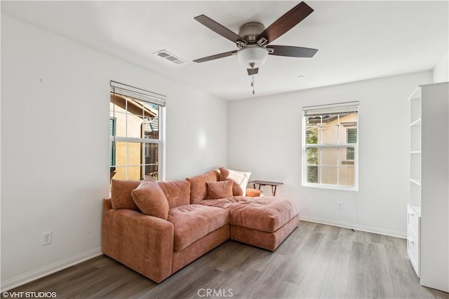 living room with ceiling fan, plenty of natural light, and light wood-type flooring