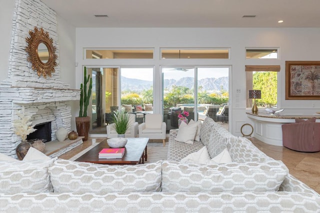 living room with a mountain view, light tile patterned floors, built in features, and a fireplace