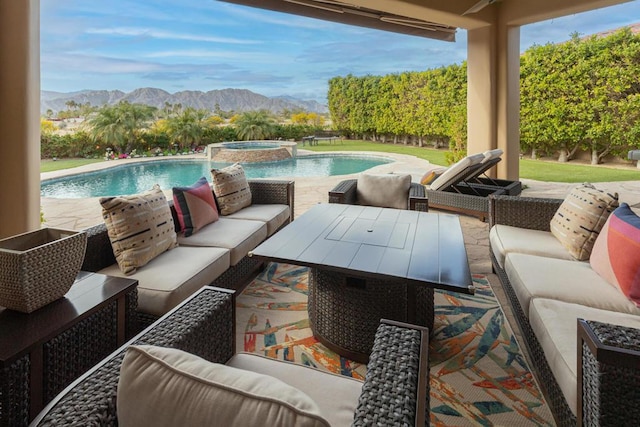 view of patio / terrace featuring a mountain view, a swimming pool with hot tub, and an outdoor hangout area