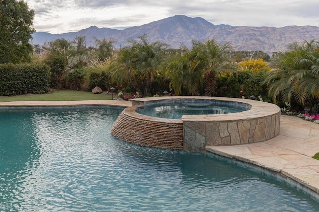 view of swimming pool featuring a mountain view and an in ground hot tub