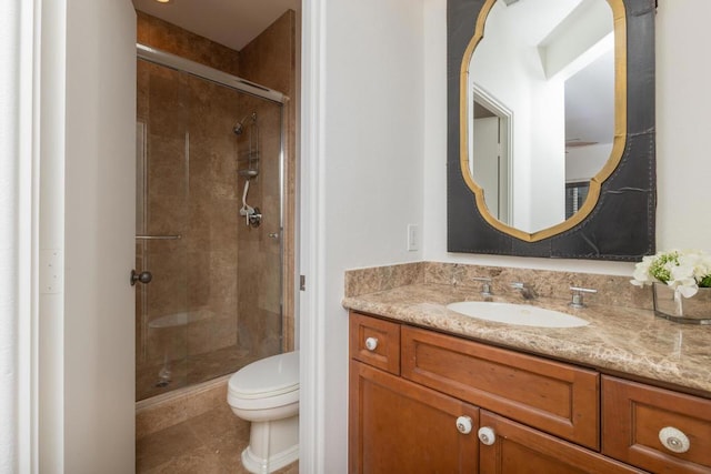 bathroom featuring toilet, a shower with door, and vanity