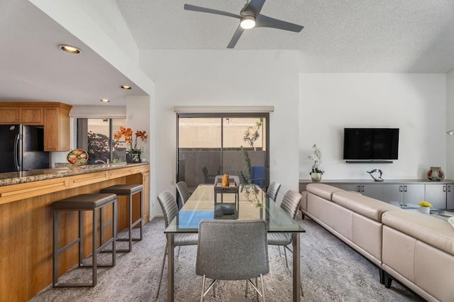 carpeted dining room with a textured ceiling, ceiling fan, and plenty of natural light