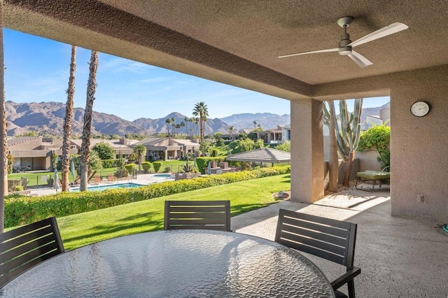 view of patio / terrace featuring ceiling fan and a mountain view