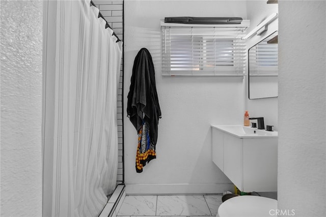 bathroom featuring toilet, vanity, and curtained shower