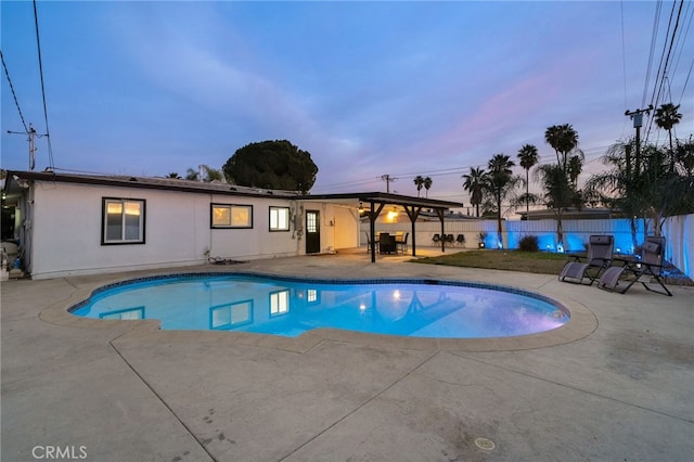 pool at dusk with a patio