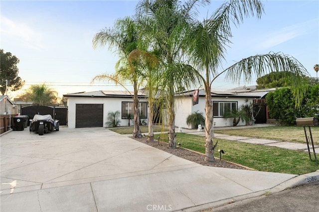 single story home featuring a garage and a yard