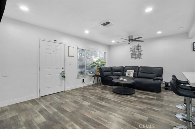 living room featuring ceiling fan and wood-type flooring