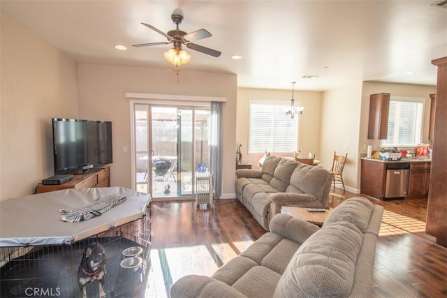 living room with light hardwood / wood-style flooring and ceiling fan with notable chandelier