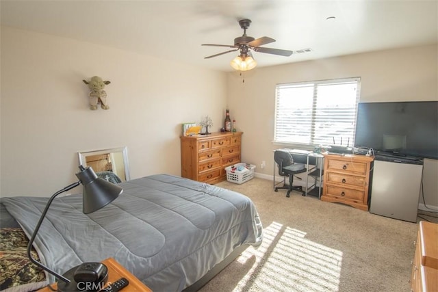 carpeted bedroom featuring ceiling fan and fridge