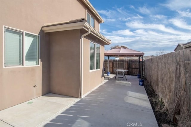 view of property exterior with a gazebo and a patio