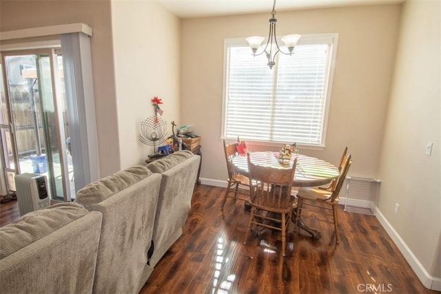 dining space with dark hardwood / wood-style flooring, an inviting chandelier, and radiator