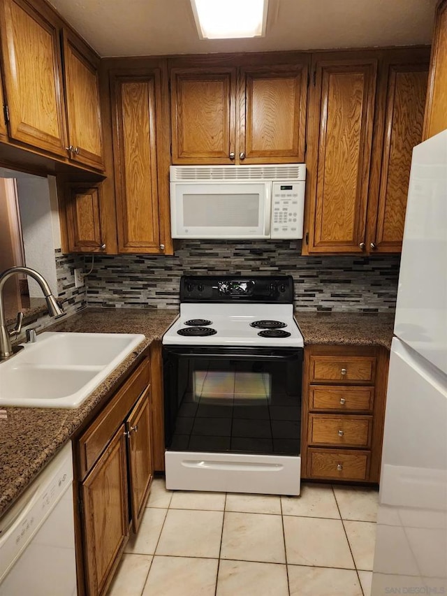 kitchen featuring backsplash, sink, white appliances, and light tile patterned floors