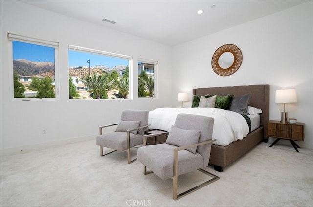 bedroom with a mountain view and light carpet