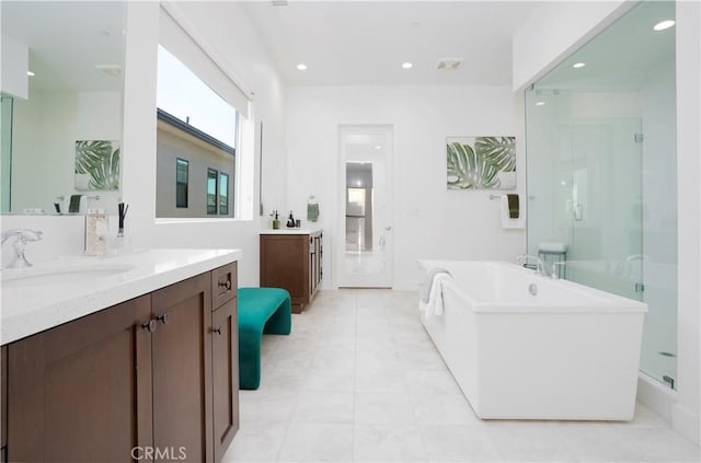 bathroom with plus walk in shower, tile patterned floors, and vanity