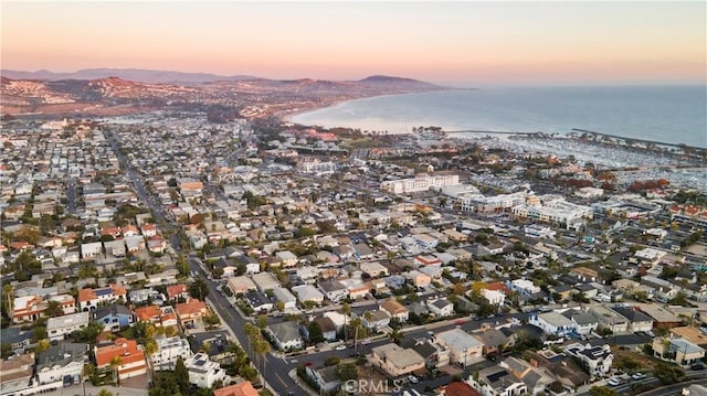 aerial view at dusk featuring a water view