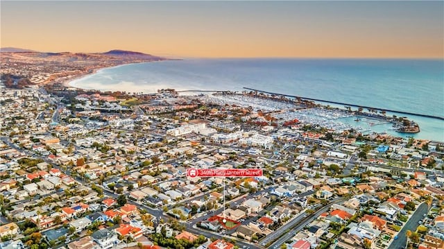 aerial view at dusk featuring a water view