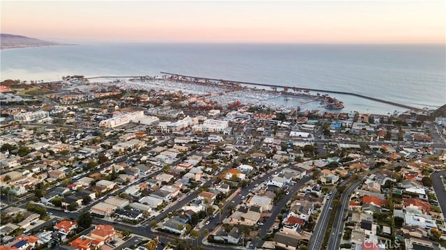 aerial view at dusk featuring a water view