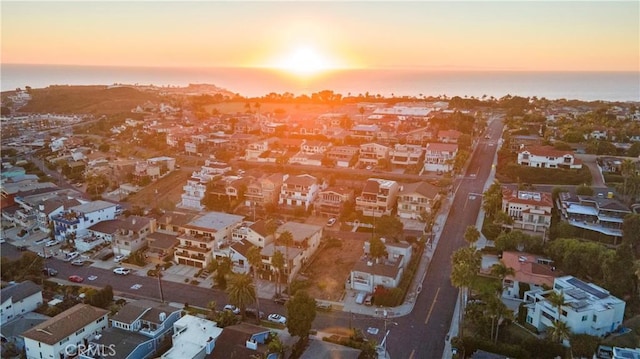 aerial view at dusk featuring a water view