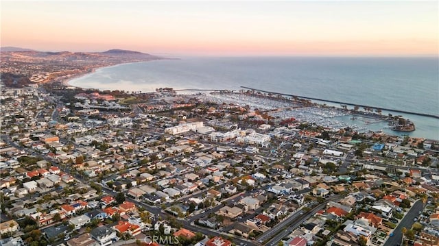 aerial view at dusk featuring a water view