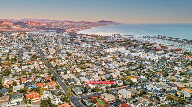 aerial view at dusk featuring a water view