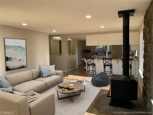 living room featuring a wood stove and hardwood / wood-style floors