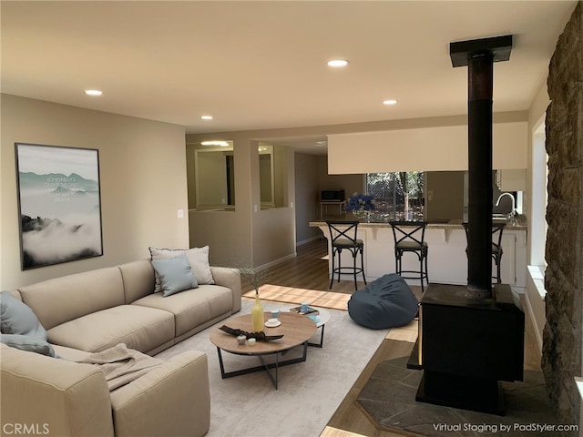 living room with wood-type flooring and a wood stove