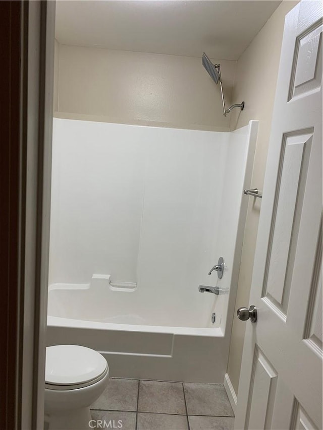 bathroom with tile patterned flooring, shower / bathtub combination, and toilet