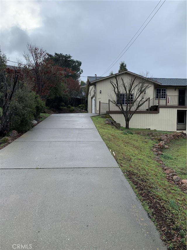 view of side of home featuring a garage and a yard