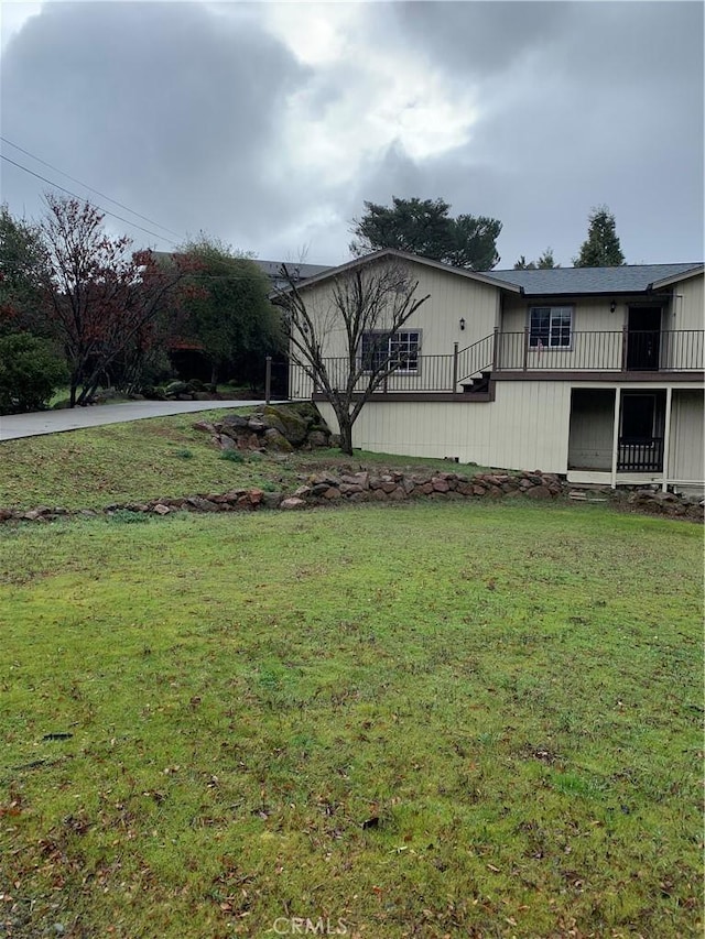 view of front of home featuring a balcony and a front yard