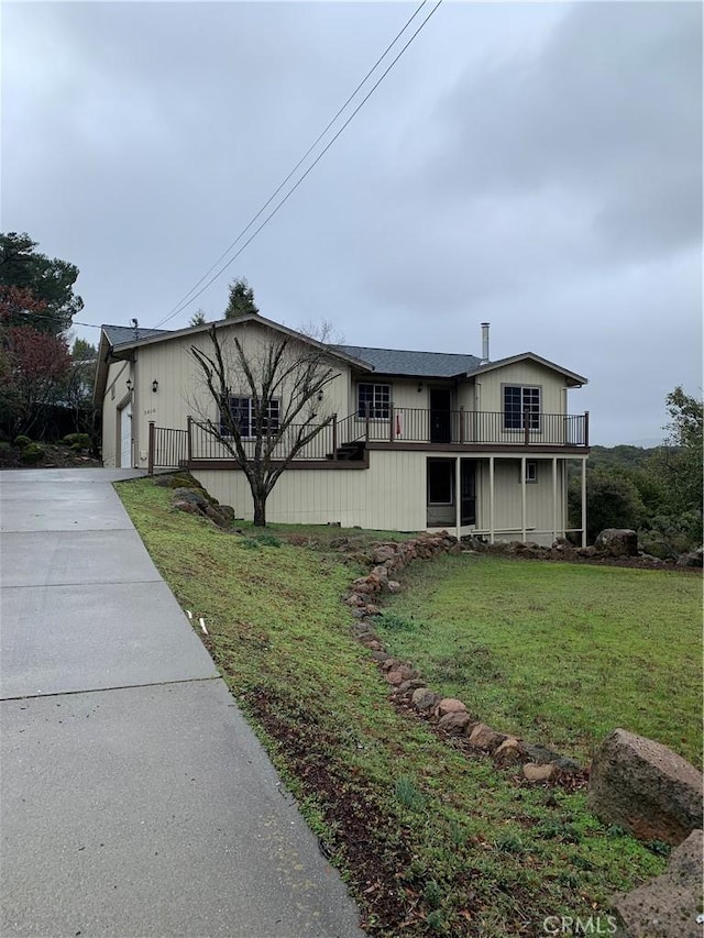 view of front of home featuring a balcony, a garage, and a front lawn