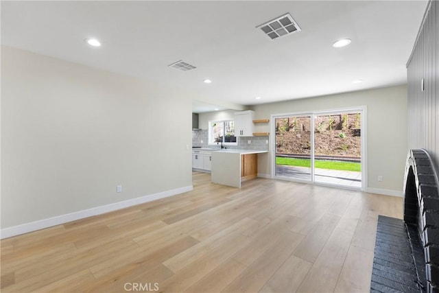 unfurnished living room featuring light hardwood / wood-style floors and sink