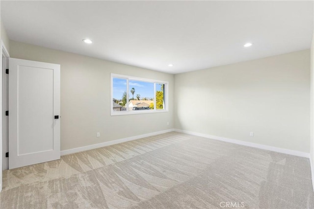 unfurnished room featuring light carpet