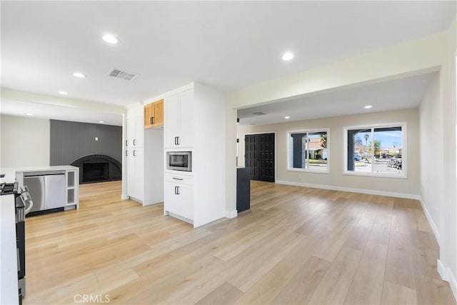 interior space with light wood-type flooring and a large fireplace