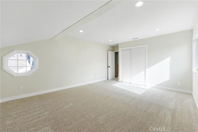 spare room featuring vaulted ceiling and light colored carpet