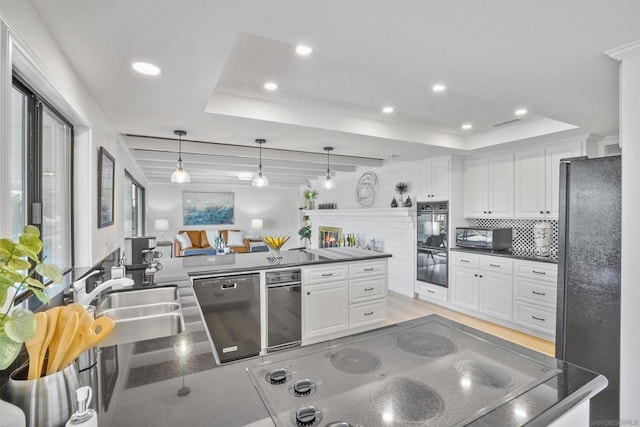 kitchen with decorative light fixtures, white cabinets, a tray ceiling, and black appliances